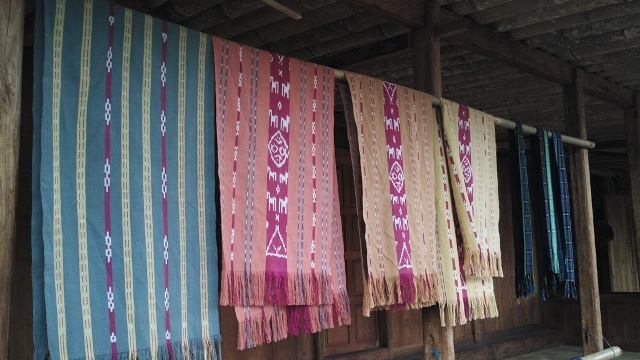 Kain tenun khas Kampung Adat Bena yang menggantung di depan rumah, kain tenun ini dijual untuk wisatawan yang tertarik memilikinya