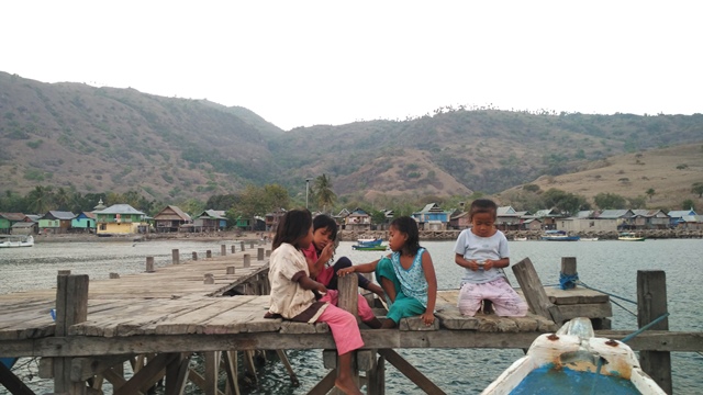 Anak - anak sedang bermain di dermaga Kampung Komodo